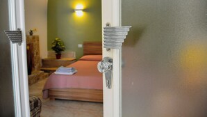 A bedroom with a bed, a nightstand, a lamp, and a wall-mounted light fixture. - Casa Mimì (Montemilone)
