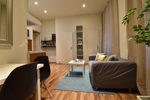 Ein kompakter Wohnraum mit Essbereich, einer Couch und einem kleinen Tisch.