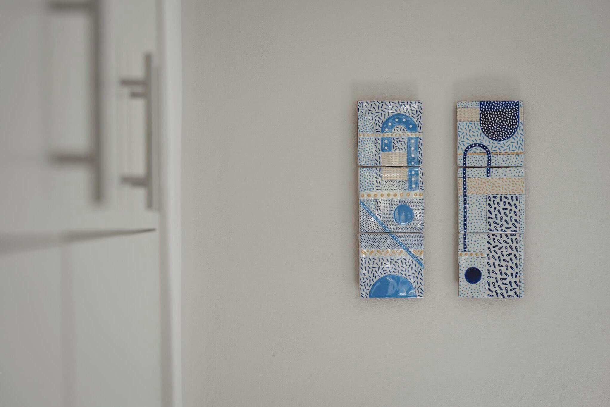 Two wall-mounted decorative panels with geometric patterns and blue accents.