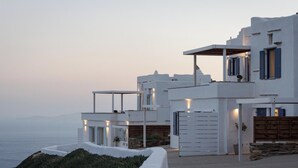 Un bâtiment moderne, de couleur blanche, doté de nombreux balcons, d’un mur en pierre et offrant une vue sur la mer.