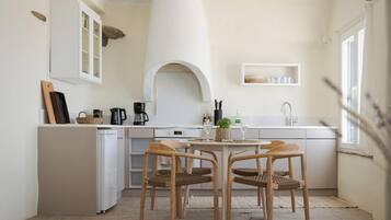 Kokeplater, kaffetrakter/tekoker, høy barnestol og spisebord