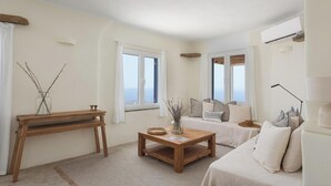 Une pièce chaleureuse avec une table en bois, deux lits et une grande fenêtre donnant sur un beau paysage.