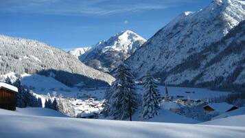 A snow-covered mountain landscape with a small village and a church.