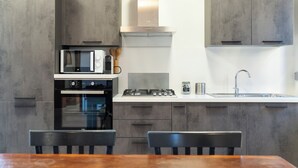 A modern kitchen with grey cabinets, a built-in oven, a microwave, a gas stove, and a sink. - Todi center -Elegant apartment with Spectacular View. Unmissable Terrace! (Todi)