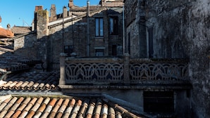 A historic building with a stone facade, a tiled roof, and a decorative metal railing. - Todi center -Elegant apartment with Spectacular View. Unmissable Terrace! (Todi)