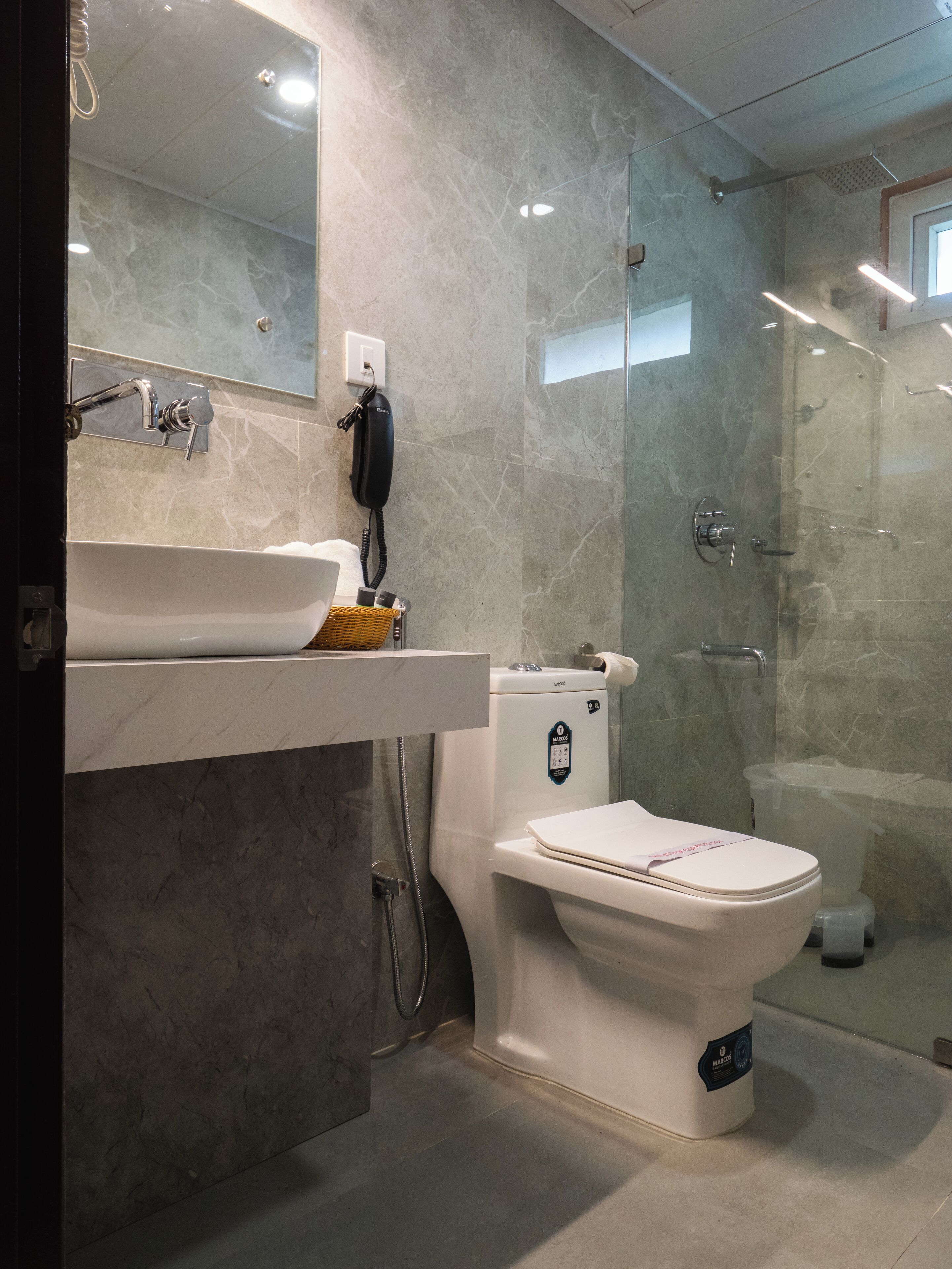 Ein modernes Badezimmer mit einem мраморном Waschbecken, einer Toilette und einer Duschkabine.