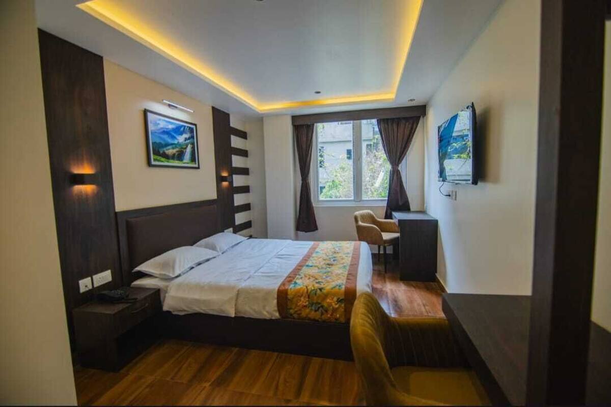 Una habitación de hotel moderna con cama, mesita de noche, escritorio y silla.