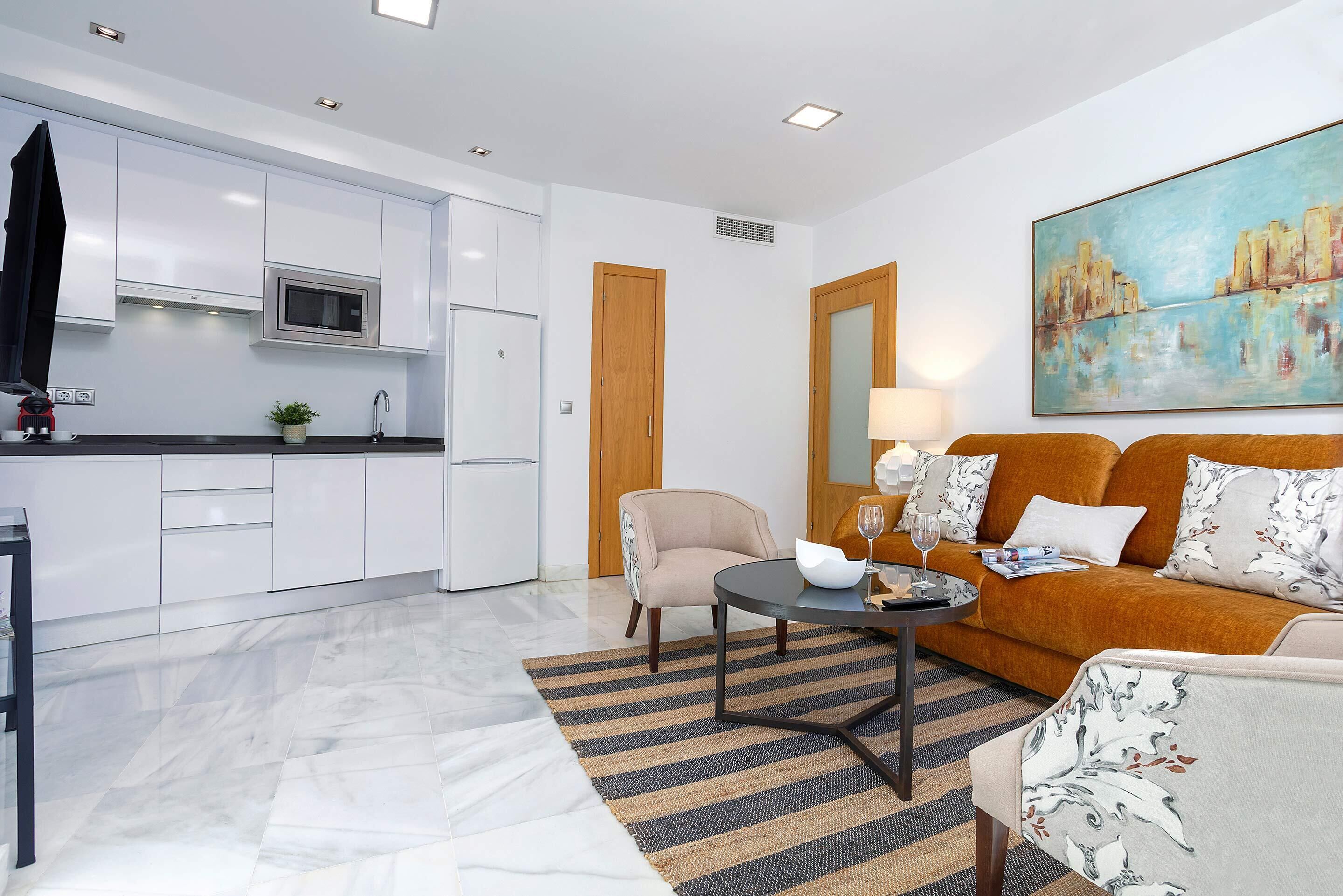 Una sala de estar moderna con un sofá, una mesa de centro y un cuadro en la pared.