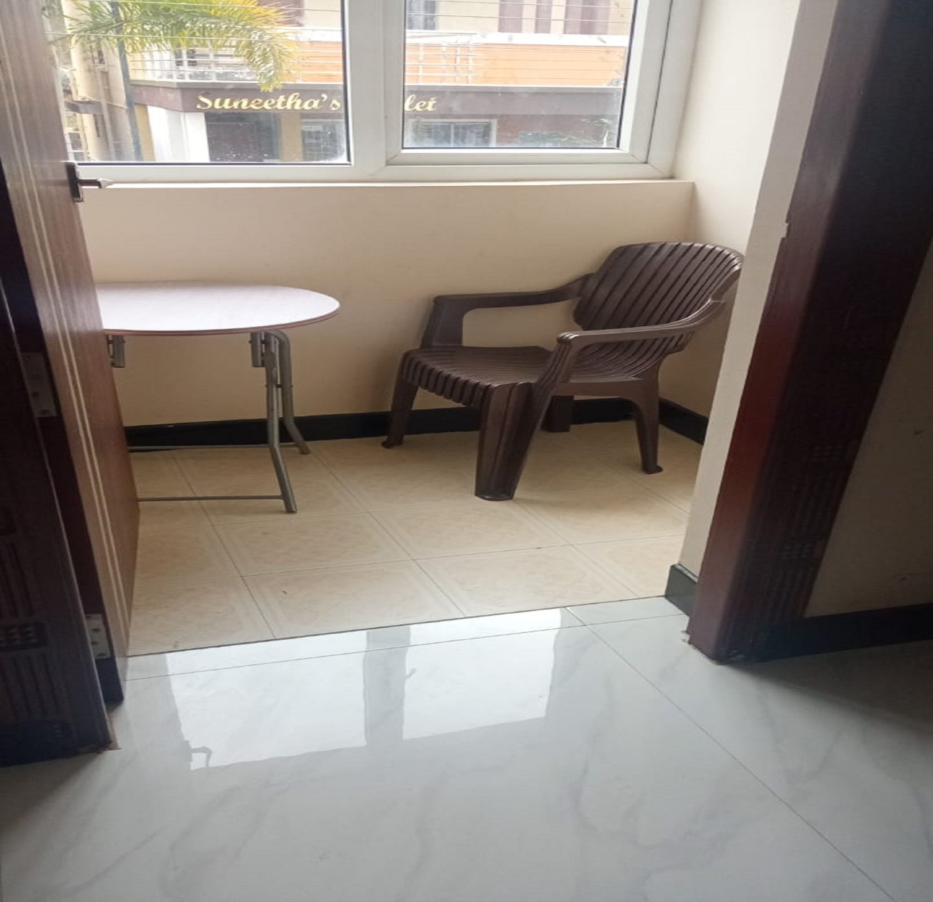A small room with a window, a table, and two chairs.