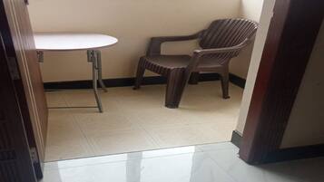 A small room with a window, a table, and two chairs.