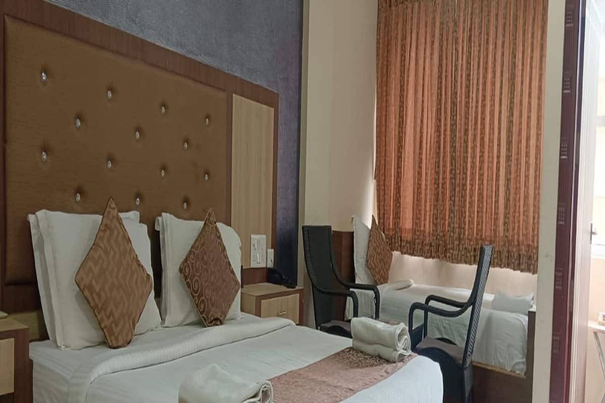 A hotel room with a large bed, two nightstands, a desk, and a chair.