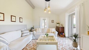 Ein Wohnzimmer mit einer Couch, einem Couchtisch und einer Pendelleuchte.