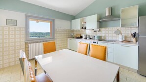 Eine moderne Küche mit Essbereich, einem Fenster mit Blick und einem eingebauten Herd.