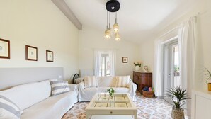 Ein Wohnzimmer mit einer Couch, einem Couchtisch und einer Tür, die auf einen Balkon führt.