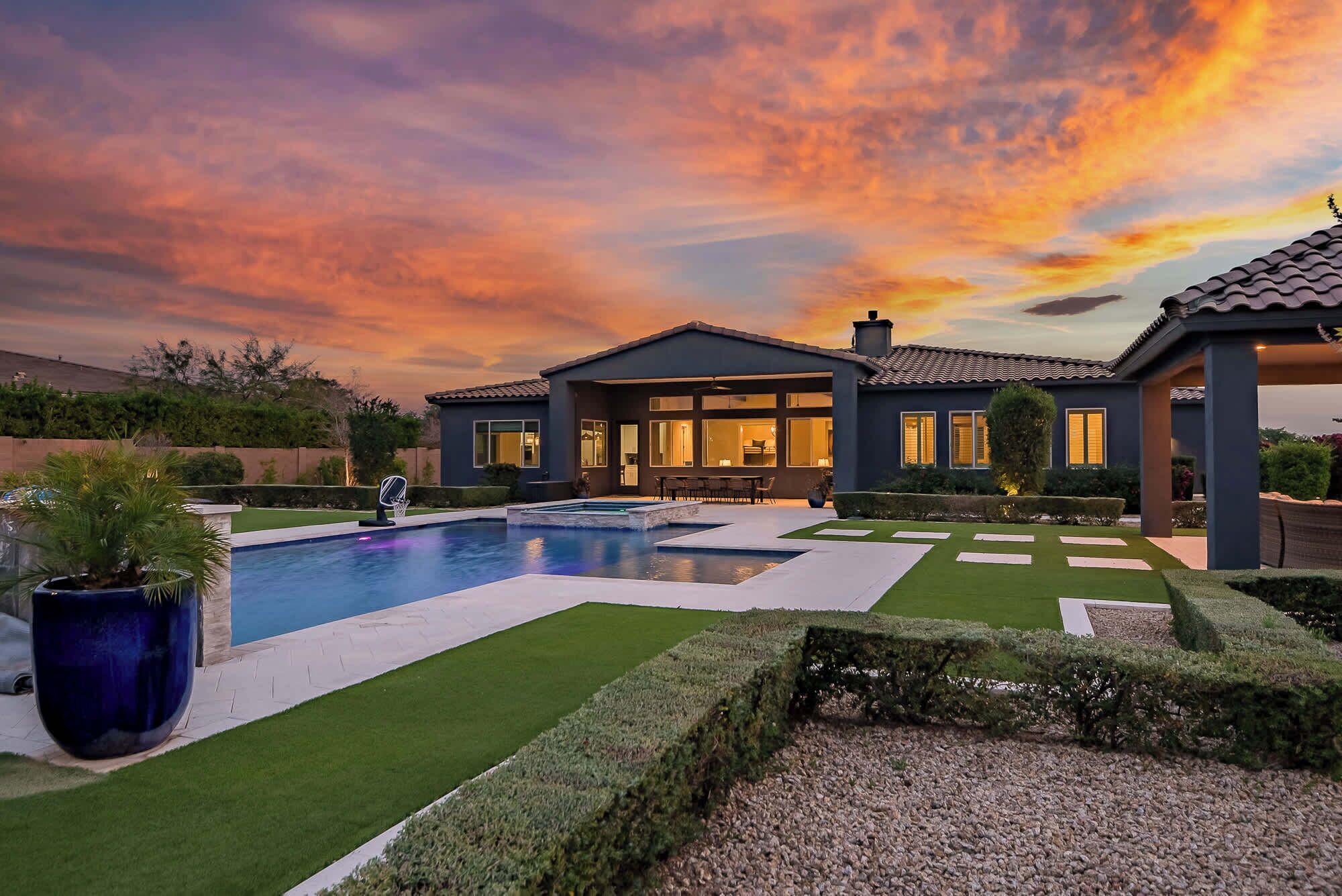 Una casa moderna con piscina, césped cuidado y un espacio de patio.