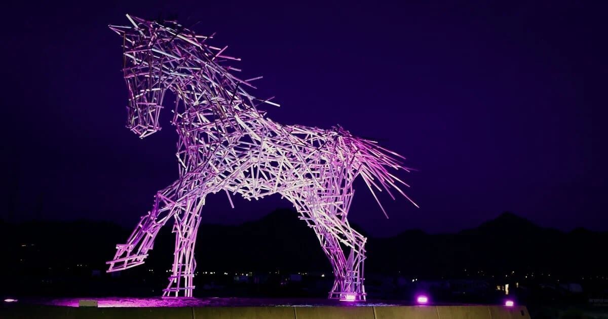 A large, illuminated sculpture of a horse.
