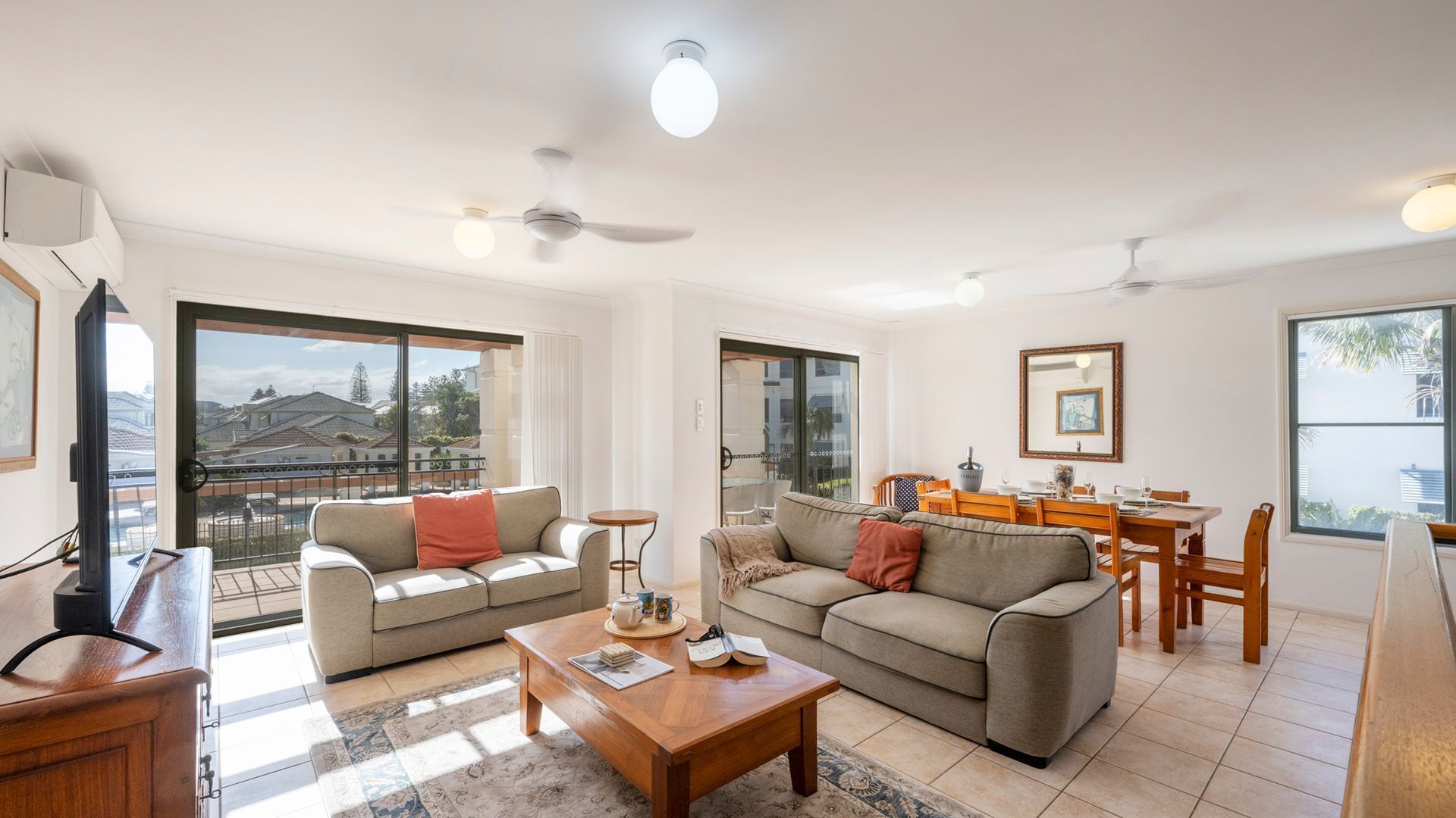A modern living room with a sofa, coffee table, and dining area.