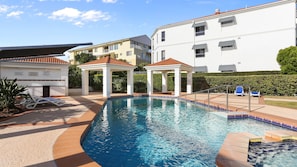 A swimming pool with lounge chairs and a gazebo. - Breakers Block 3 Unit 2 - Lifestyle Yamba (YAMBA)