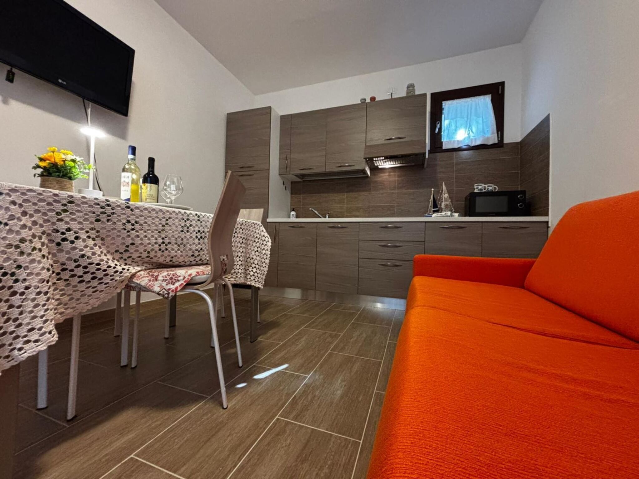 Un espace de vie compact comprenant un coin repas, une kitchenette et un canapé.