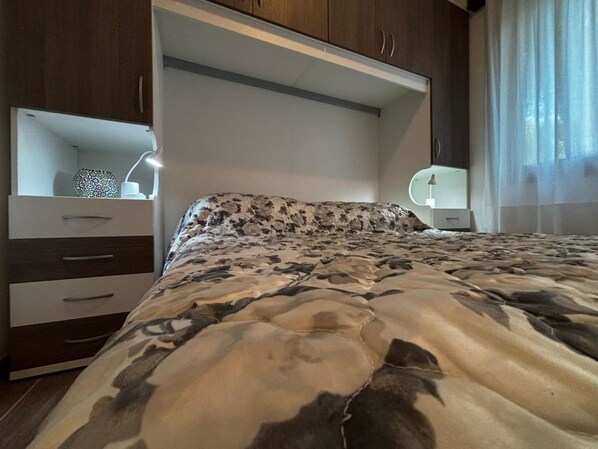 Une chambre à coucher avec un lit, une commode et un miroir.
