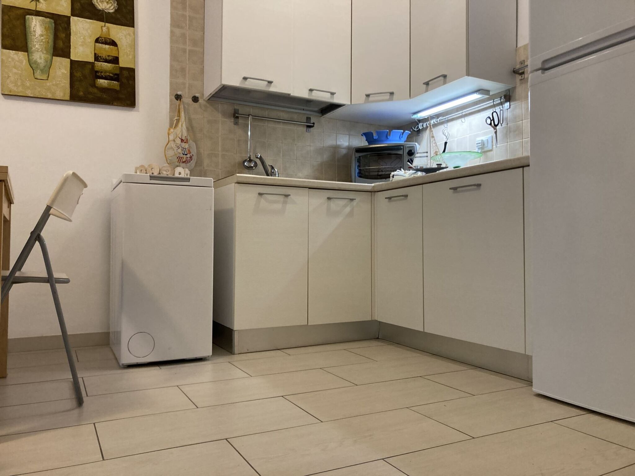A kitchen with white cabinets, a built-in oven, and a microwave.
