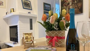 A table with a bottle of BortoloMioIol wine, a SlowPolesine magazine, and a bouquet of tulips. - Modern Flat Just 150 mt From the sea (Rosolina)