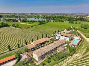Eine große Villa mit Swimmingpool, umgeben von Weinbergen und einem See.