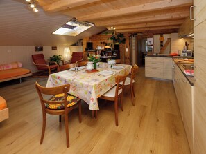 A cozy dining area with a wooden table set for four, surrounded by wooden chairs.