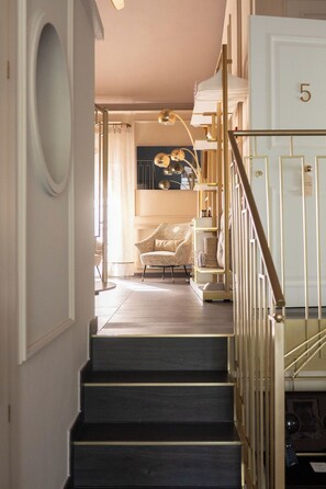 A staircase leading to a room with a chair and a shelf. - Maison Chambre & Jardin (San Martino in Rio)