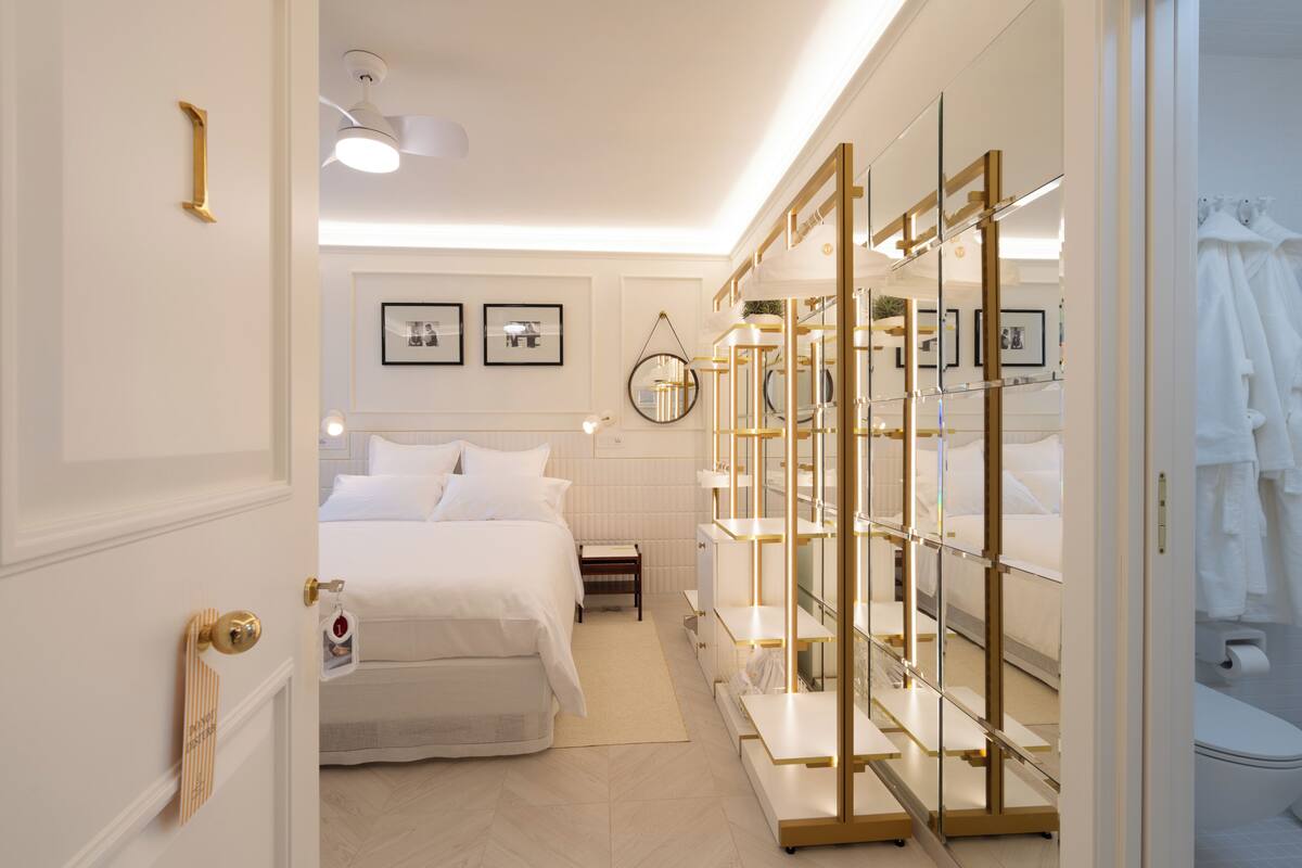 Une chambre d’hôtel comprenant un lit, une table de chevet, une armoire et un miroir.