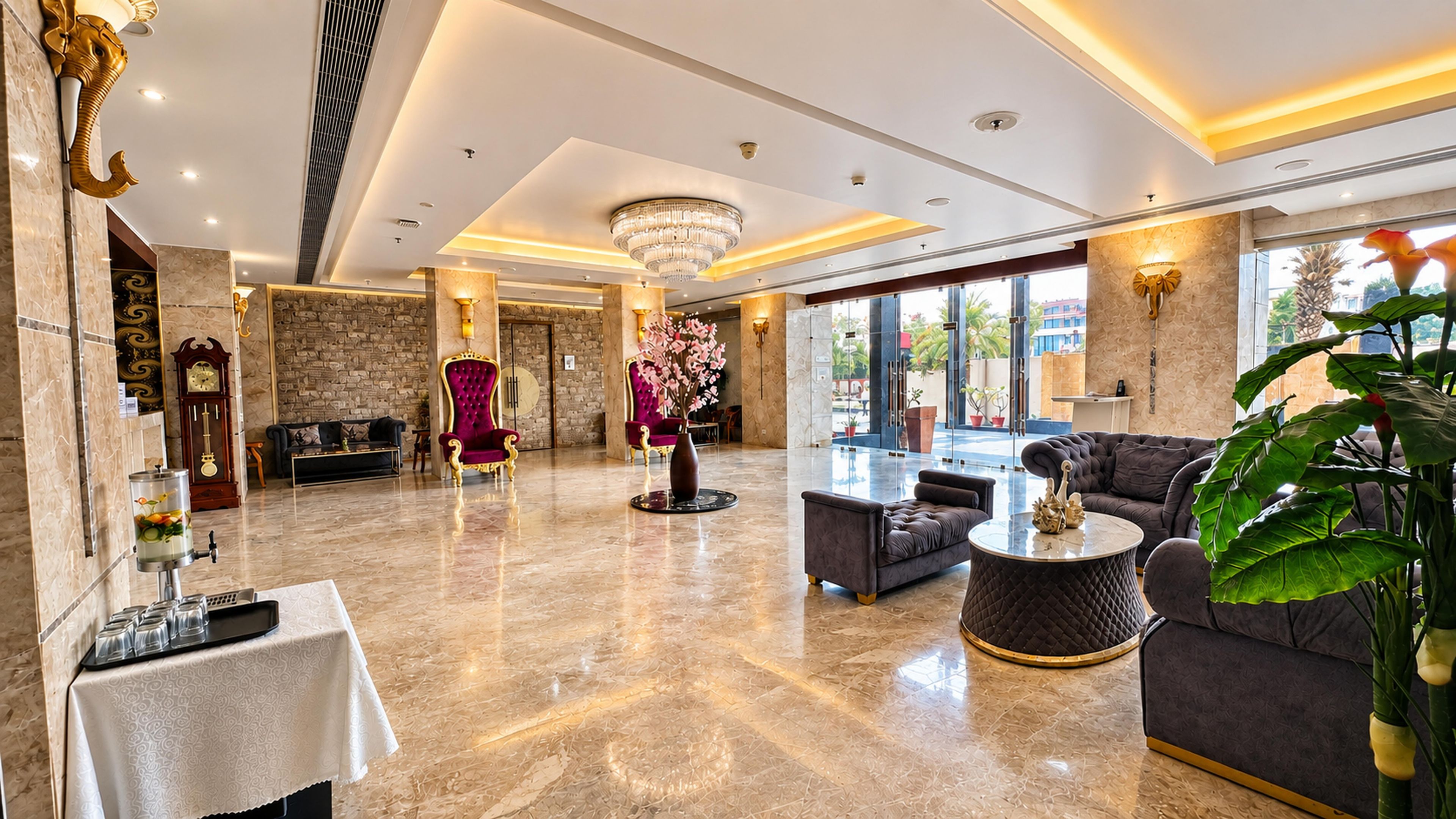 A spacious lobby with a marble floor, a grand chandelier, and a seating area with sofas and a coffee table.