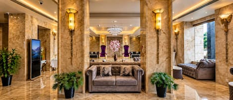 Eine luxuriöse Lobby mit Marmorböden, einer bequemen Couch und stilvollen Leuchten.