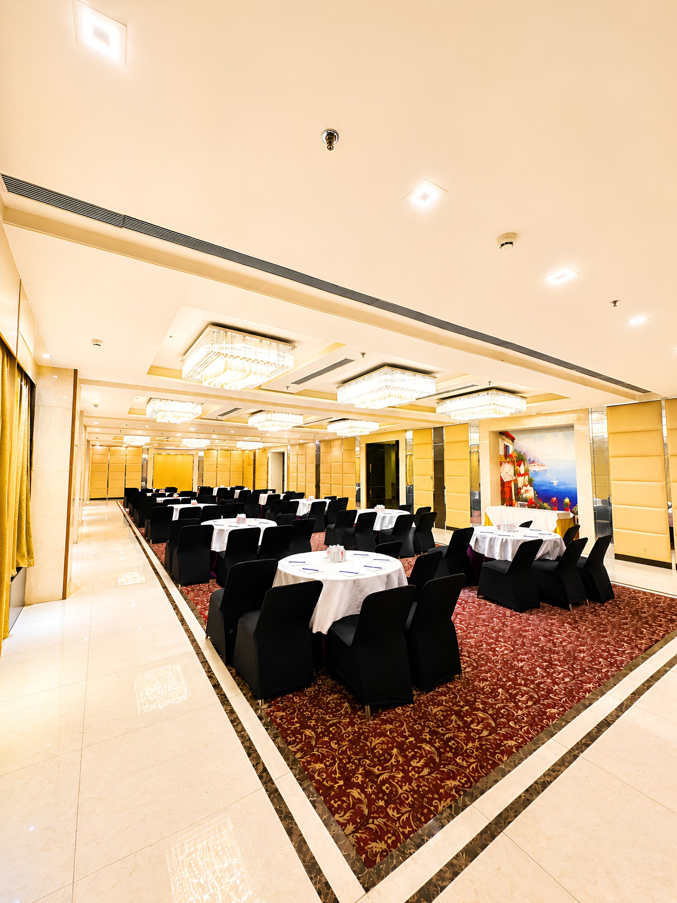 A conference room with multiple tables and chairs, a patterned carpet, and a decorative wall mural.