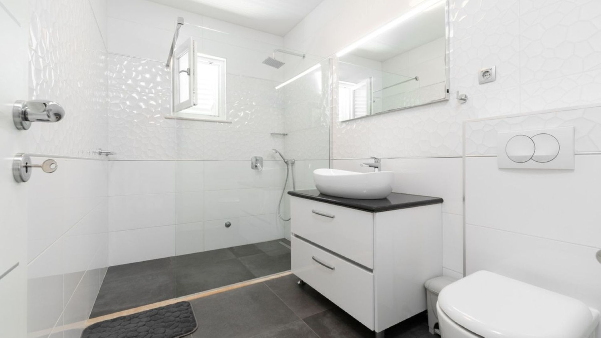 Un baño moderno con ducha, lavabo e inodoro.