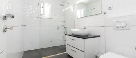 Un baño moderno con ducha, lavabo e inodoro.