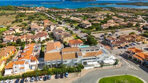 A coastal town with a prominent mountain in the background, featuring a mix of residential buildings and open spaces. - A cozy space ideal for two people, designed for comfort and tranquility. The sleeping area can be arranged with a double bed or twin beds, depending on the guests' needs.Most units feature a veranda or garden furnished with a table and chairs, perfect fo (Porto San Paolo)