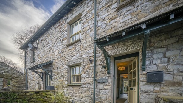 Un bâtiment en pierre avec une enseigne indiquant « À proximité de Todd » et une porte donnant sur un hall d’entrée.