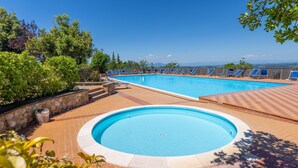 Une piscine avec des chaises longues et une vue sur les montagnes.