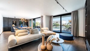 Una sala moderna con sofá, mesa de centro y comedor con barra.