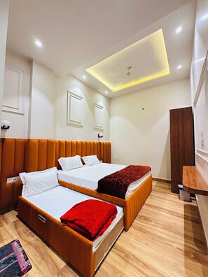 A modern hotel room with a large bed, a smaller bed, and a desk. - hotel cloud 9 (Amritsar)