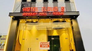 Een hotel met een bord waarop 'HOTEL CLOUD 9' en 'ZAAL / KAMERS' staat.