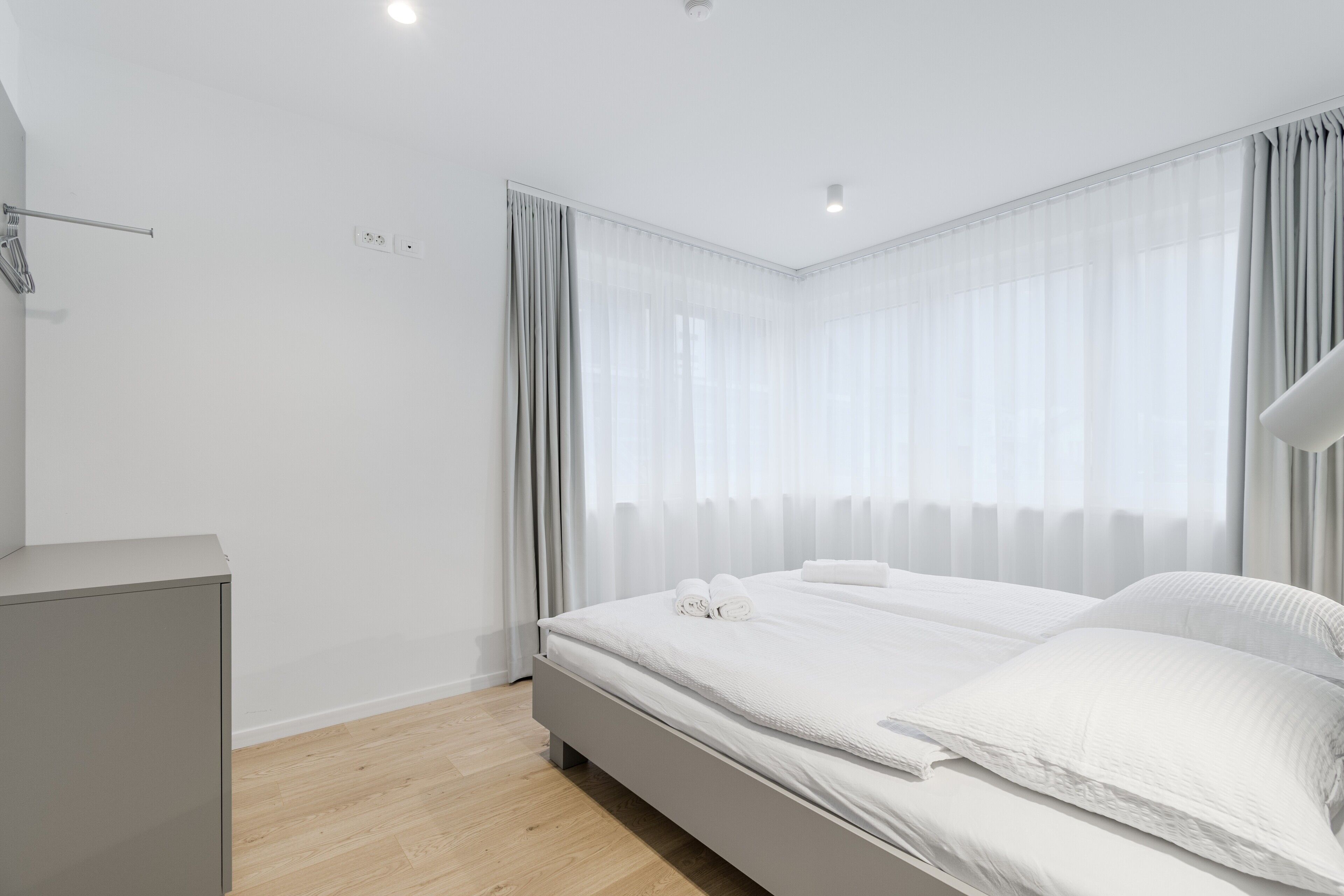 Ein modernes Schlafzimmer mit einem großen Bett, einem Nachttisch und einem Kleiderschrank.