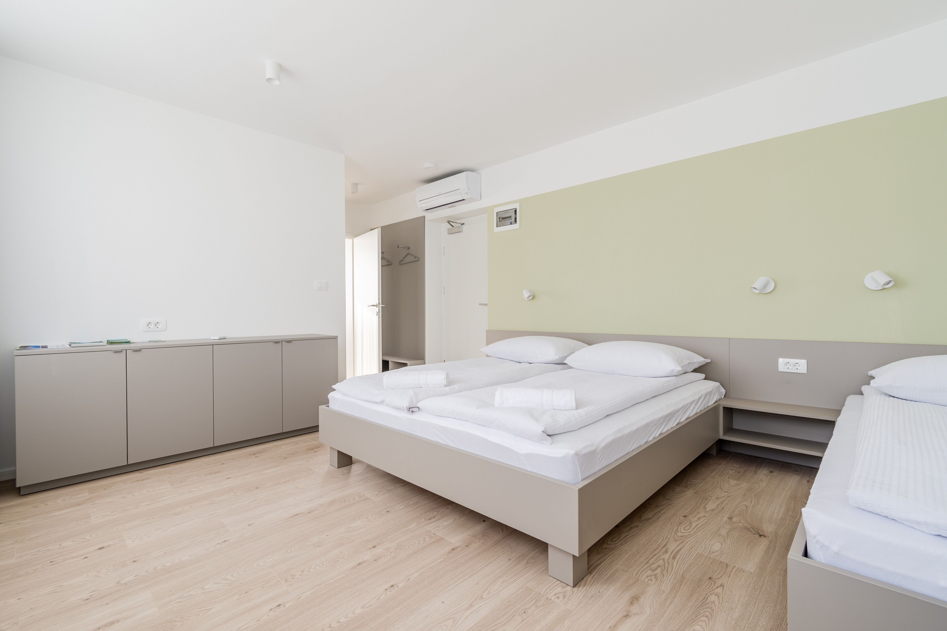 Ein modernes Schlafzimmer mit einem großen Bett, einem Kleiderschrank und einem begehbaren Kleiderschrank.