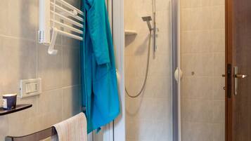 A bathroom with a shower, a bathtub, and a towel rack.