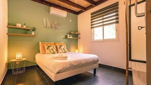 Un dormitorio ordenado con cama, lámparas de noche y estanterías con objetos decorativos.