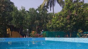 Une piscine d’un bleu éclatant, bordée de carreaux et dotée de marches menant à l’eau.