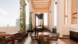 A rooftop terrace with wicker furniture, a central table, and potted plants. - Delightful Trizen 1-bedroom apartment with AC in Colombo 02 (Colombo 02)