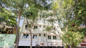 Un edificio de varios pisos con fachada plana, varias ventanas y una entrada visible.