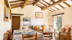 A dining area with wooden furniture, a tiled floor, and a framed picture on the wall. - Holiday Home “Gîte Des Hiboux” with Shared Pool, Private Terrace & Wi-Fi (Sanxay)