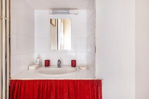 A bathroom with a white sink, a mirror, and a red towel. - Bed and Breakfast 'Chambre Klimt' with Shared Pool, Shared Terrace and Wi-Fi (Sanxay)